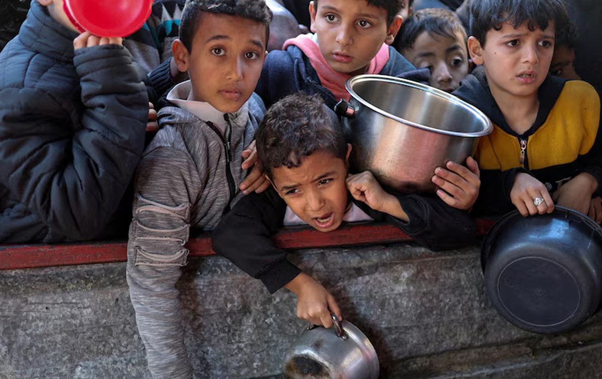 HAMBRE EN GUERRA. Niños palestinos esperan comida en un punto de distribución de ayuda humanitaria en Gaza. / UNICEF