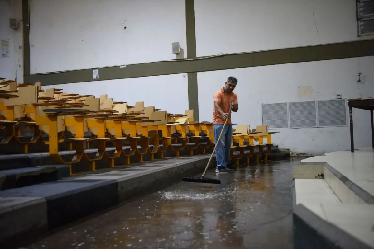 EL DÍA DESPUÉS. Empleados sacan el agua que ingresó al predio.