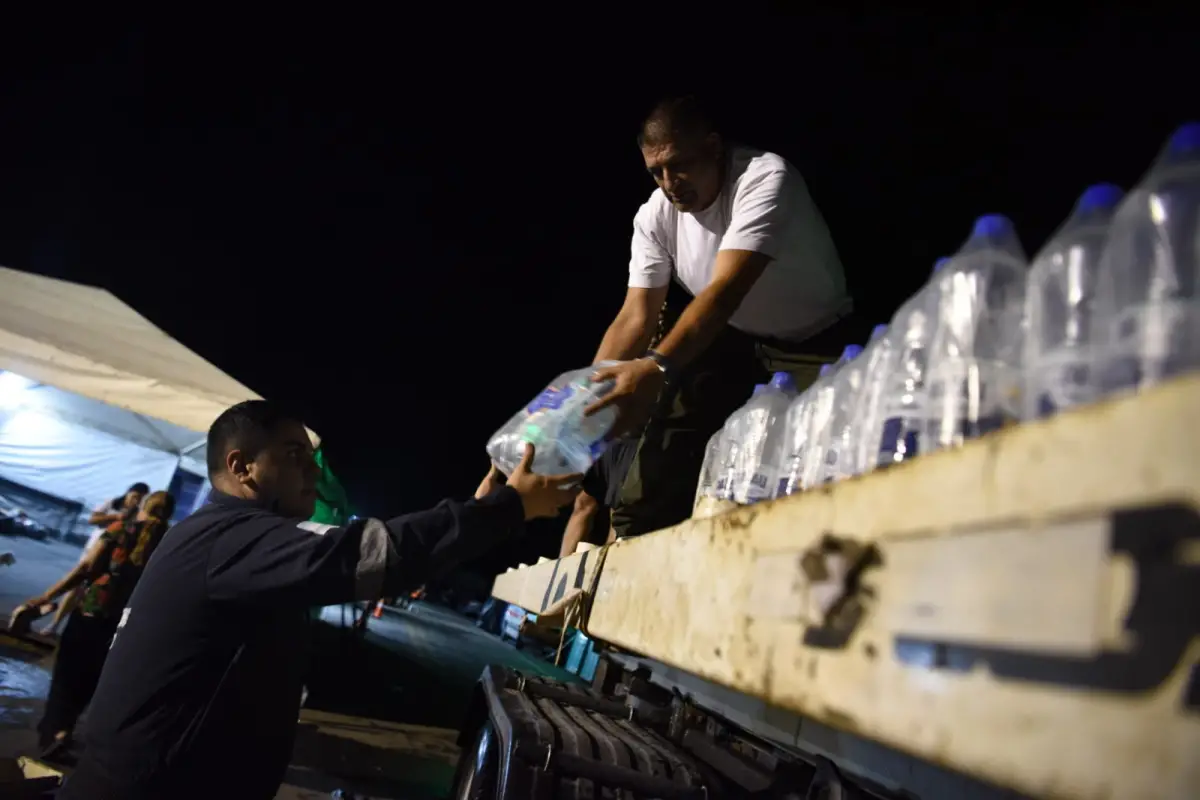 ELEMENTOS BÁSICOS. El reparto de agua potable en pleno campamento de la ruta 157, en La Madrid. LA GACETA / FOTO DE DIEGO ARÁOZ