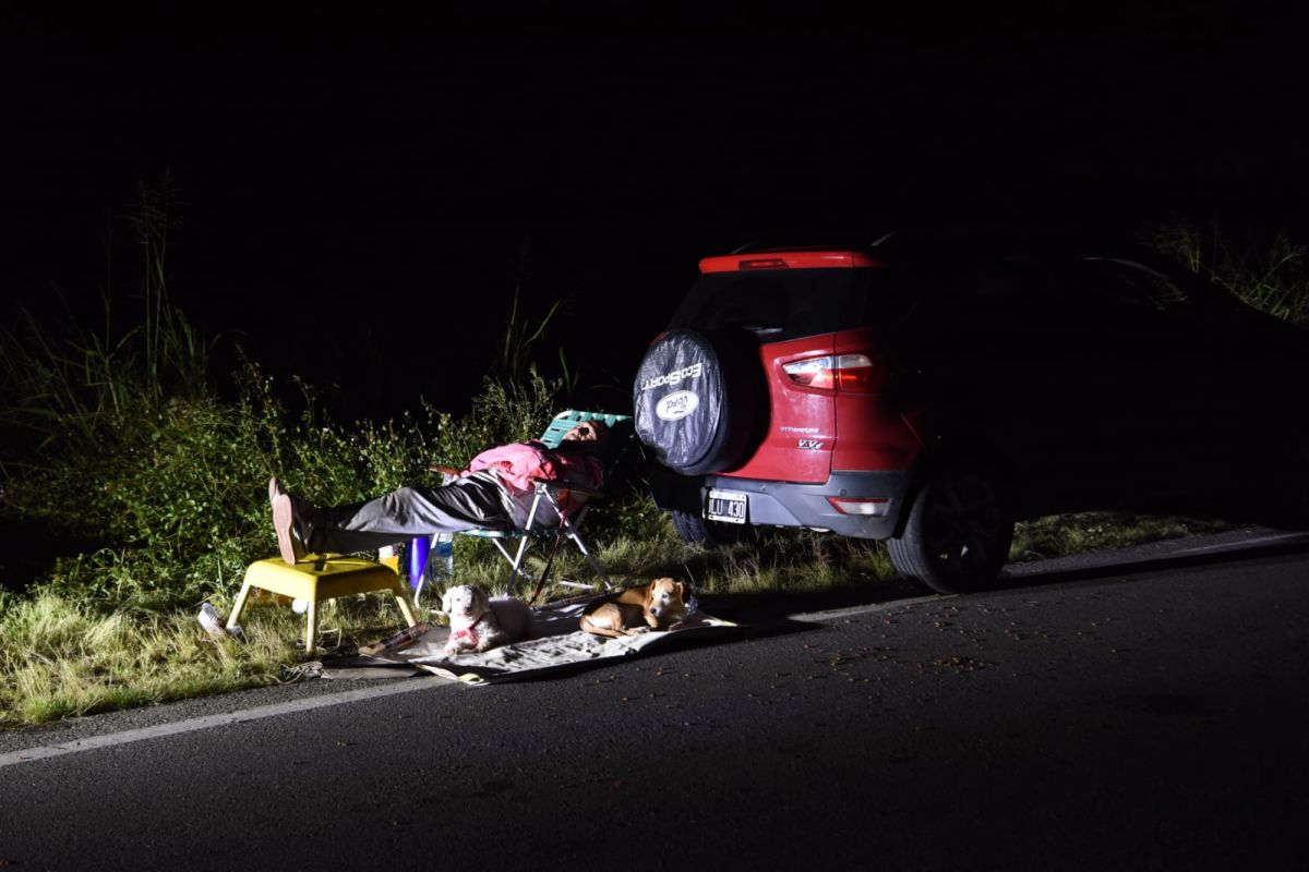 RINCÓN. Las luces de un auto iluminan a los dos perros de una familia junto a sus pertenencias y su auto en plena ruta 157. LA GACETA / FOTO DE DIEGO ARÁOZ