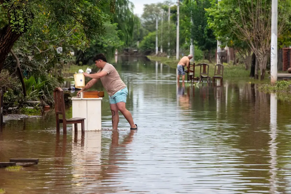 EN MEDIO DEL AGUA. La gente intenta recuperar sus pertenencias.