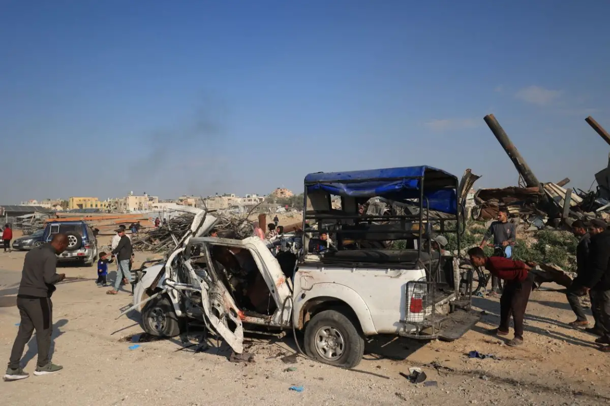 DESTRUCCIÓN. Palestinos inspeccionan el lugar de un ataque israelí sobre un vehículo policial en Zawaida, en el centro de la Franja de Gaza.   afp