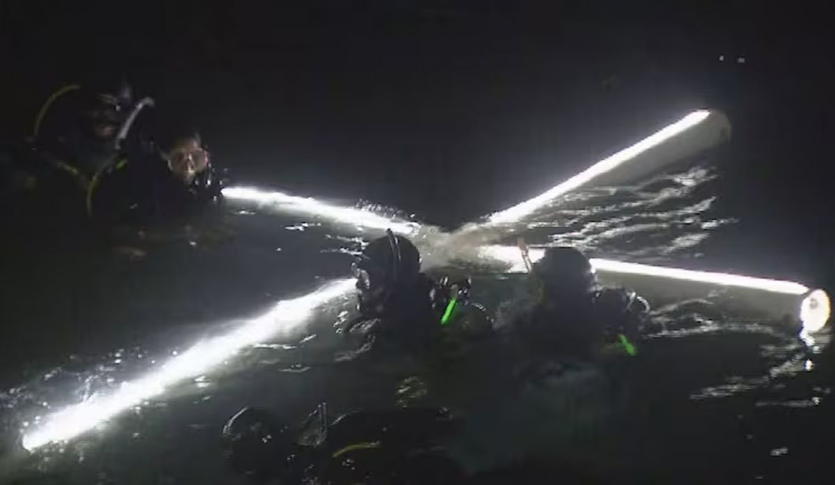 La cruz iluminada desciende en el mar del Golfo Nuevo. 