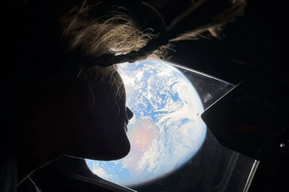 EL VIAJE EN VIVO. Christina Koch observa la Tierra desde la ventana de la nave Orion durante el vuelo de Artemis II rumbo a la Luna. / NASA