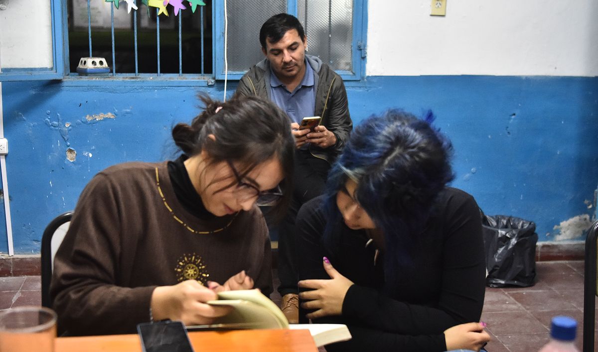 SOLANGE Y MARTINA, CON ARMANDO DETRÁS. Comparten la lectura de sus textos en el taller de escritura de La Escuelita de Famaillá. / LA GACETA, OSVALDO RIPOLL