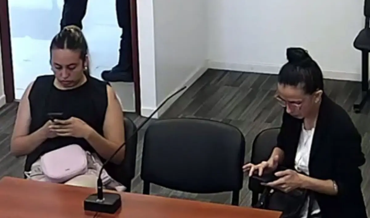 ESPERA. Florencia (izquierda) y Carolina miraron sus celulares mientras aguardaban la resolución de la jueza. 