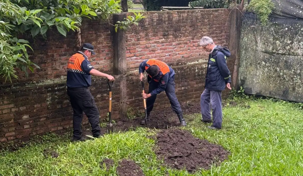 EN PLENA TAREA. Personal de Bomberos, supervisado por un especialista del ECIF, excava en el jardín de la casa allanada.