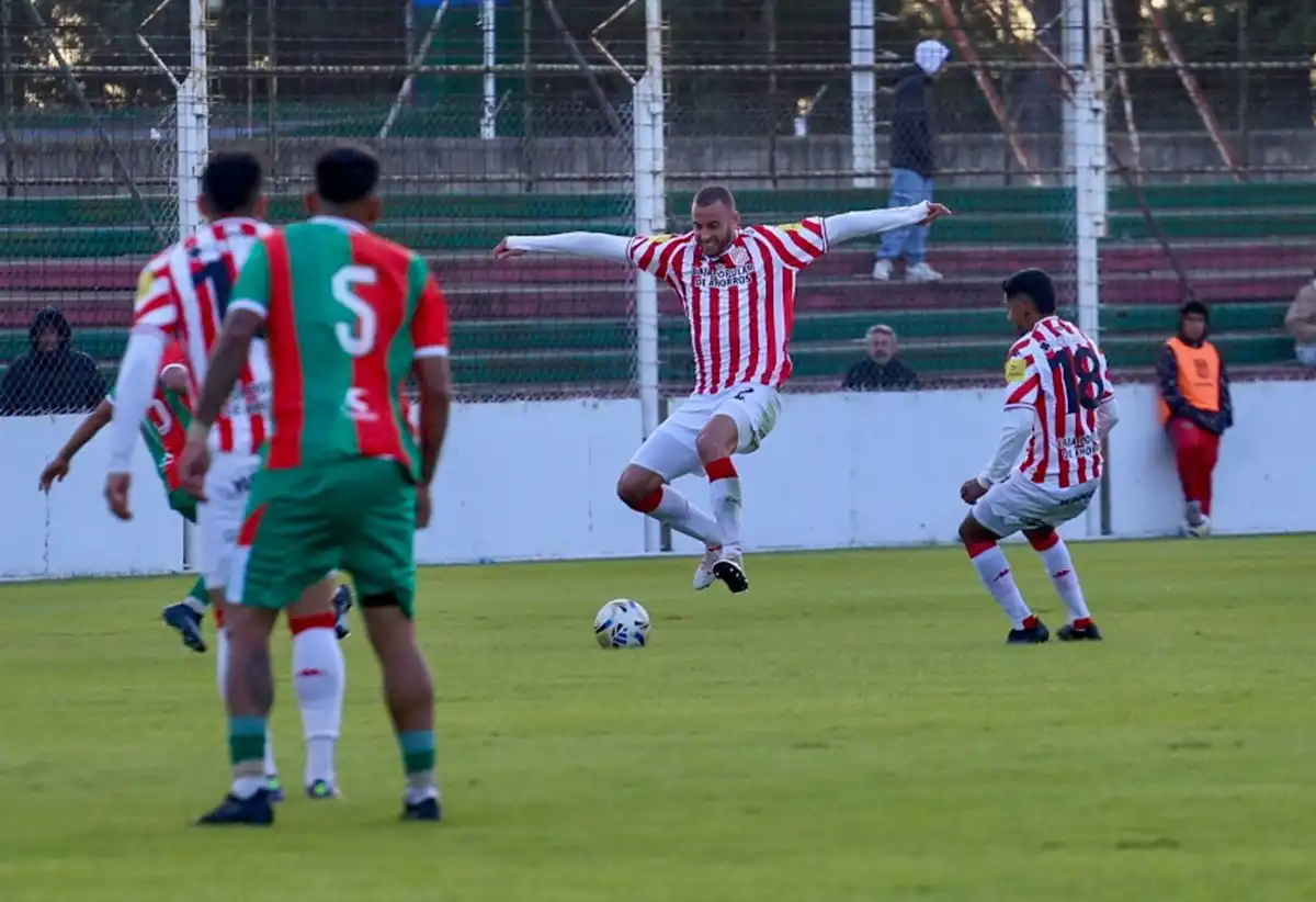 IMPULSO. Nicolás Ferreyra levanta los brazos y va a trabar la pelota, mientras Matías García observa atento la jugada.