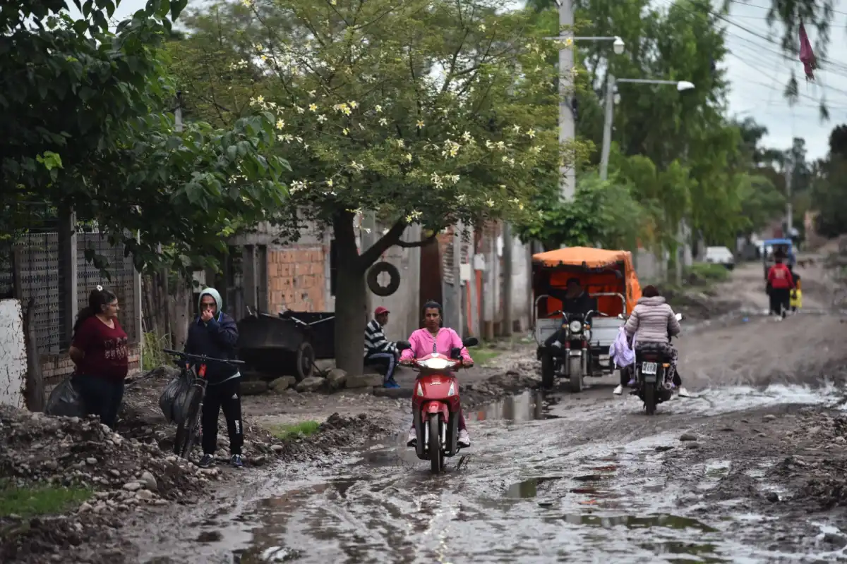PANTANO. En Crucero Belgrano, el agua acumulada cubre la calle y obliga a los vecinos a cruzar con dificultad.