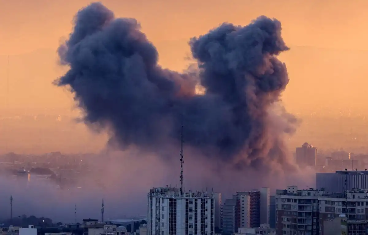 GUERRA EN MARCHA. Una columna de humo se eleva después de un ataque en Teherán. 
