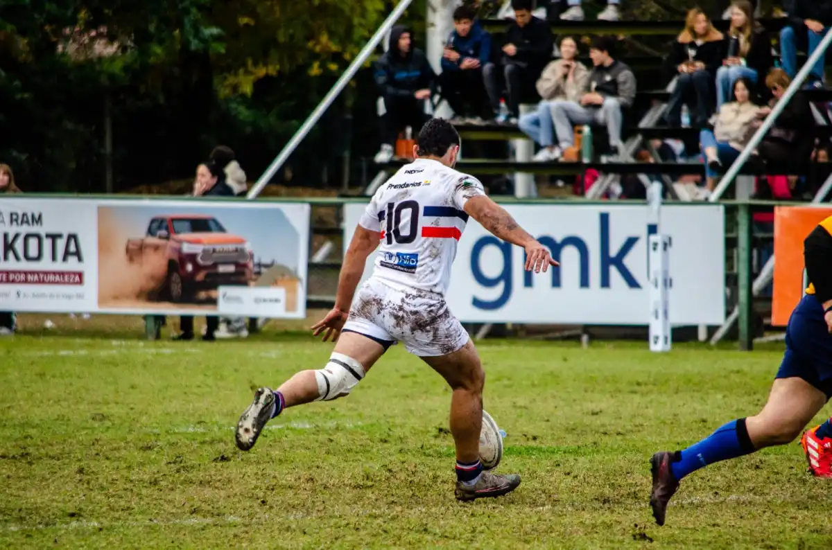 El apertura de Natación, Tomás García, realizando el kick off del partido.