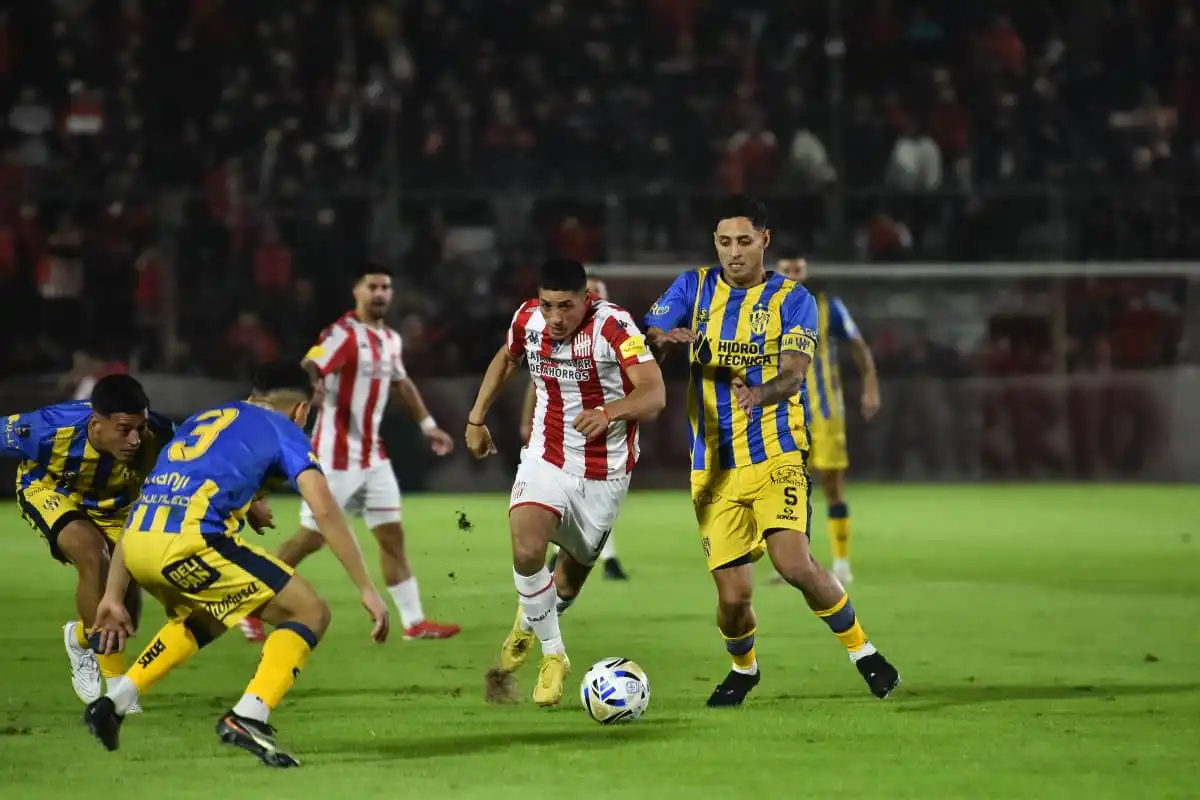 POCAS LUCES. Nicolás Castro intenta maniobrar frente a dos jugadores de Atlanta. El volante nunca encontró el camino para generar juego.