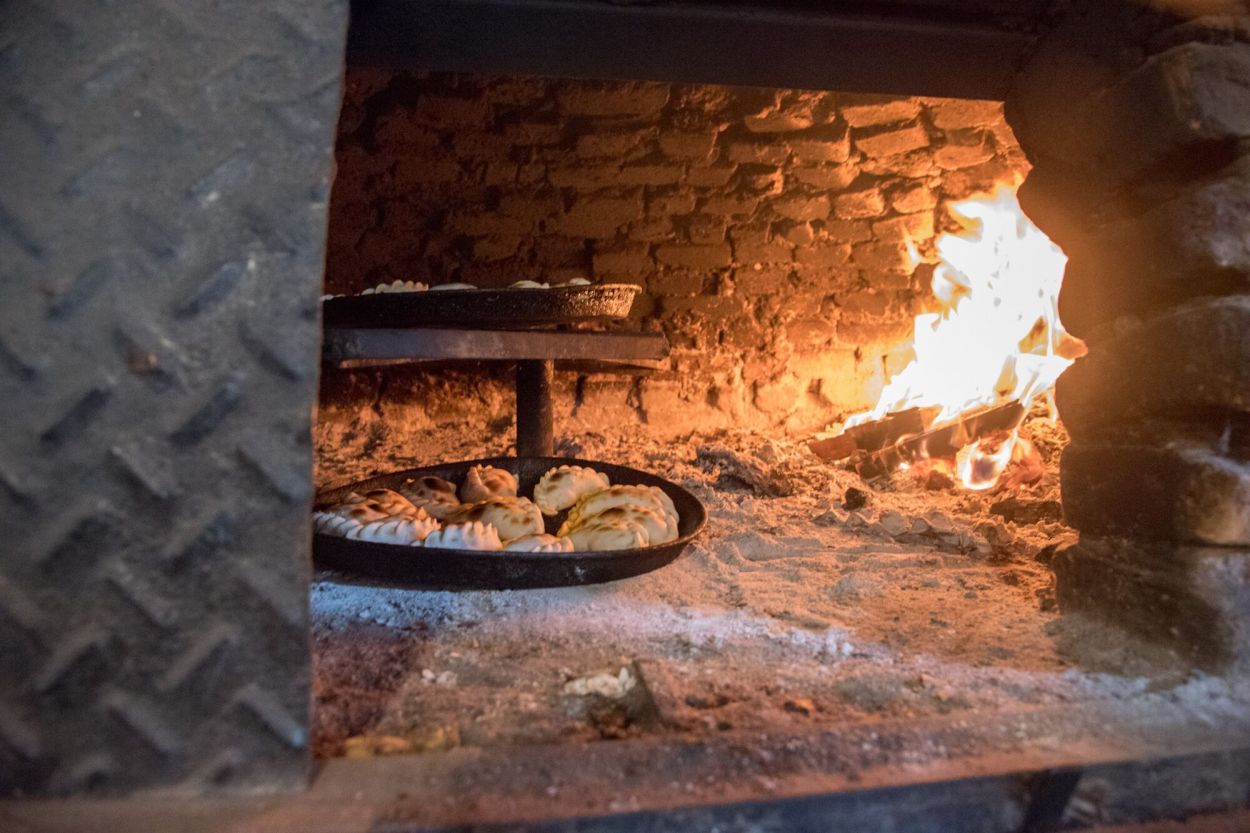 A PUNTO. Las empanadas en las asaderas, cocinándose en el horno de barro.