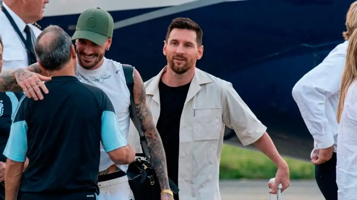 LLEGÓ EL 10. Lionel Messi baja del avión junto a su compañero Rodrigo De Paul y es recibido por los utileros de la Selección.